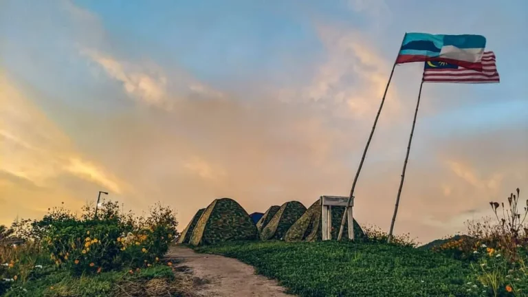 Tents and flags on the summit at dusk